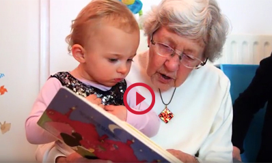 Older woman using her skills to read to young child